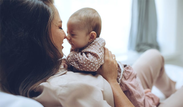 Mơ bế một bé trai đang mỉm cười